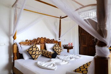 cozy bedroom with mosquito net, white mesh canopy, part of wooden bed in apartment room, hotel near...