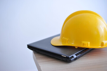 capacete amarelo de construção civil em cima de computador portatil, set para trabalhos de engenharia 