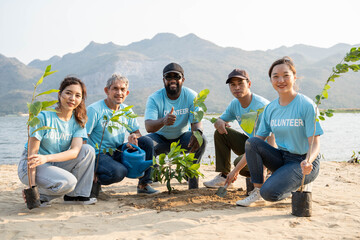 Group of volunteer smiling To Camera sitting On the beach. Protection Of Environment And Nature, Ecology Concept.