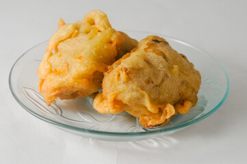 two pieces of fried tofu stuffed with vegetables served on a small plate isolated on a white background