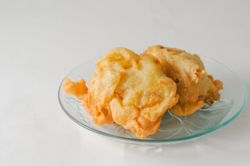 two pieces of fried tofu stuffed with vegetables served on a small plate isolated on a white background
