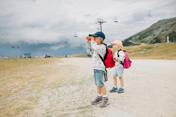 jeune gaçon regardant dans ses jumelles lors de vacances à la montagne