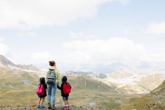maman regarde la vue avec ses enfants lors d'une randonnée à la montagne en vacances d'été