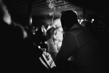 silhouette of a person at a bar smoking a cigarette.