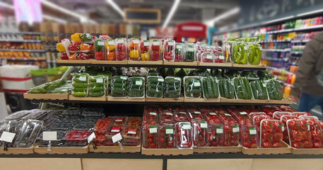 Fresh vegetables ready for sale in supermarket. Various vegetables in a large supermarket. various fresh vegetables in a large superstore. red tomatoes, green cucumber, sweet pepper. plastic packaging