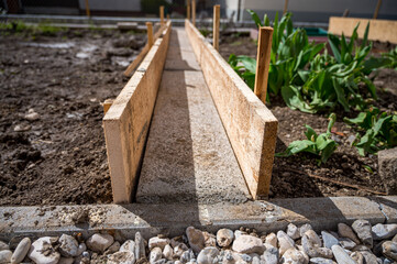 Building a concrete path through vegetable garden using wooden planks.