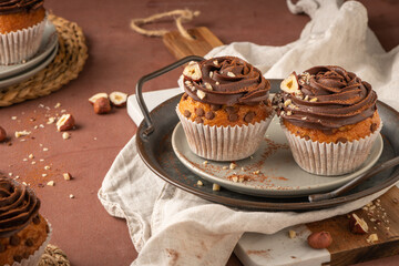 Chocolate chip muffins decorated with chocolate ganache and hazelnut
