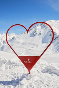 Red heart shaped frame on Val d'Isere slopes in Winter, used for skiers to take photos with. Val d'Isere, France - April 1, 2023.