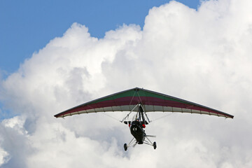 Fototapeta na wymiar Ultralight airplane flying in a cloudy sky 