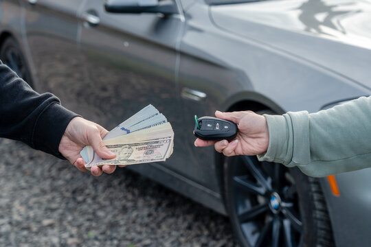 Deal of buying or renting car concept. Exchange dollars and car keys