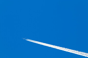 Avión a altitud de crucero con larga estela blanca en el cielo azul en Gran Canaria, España