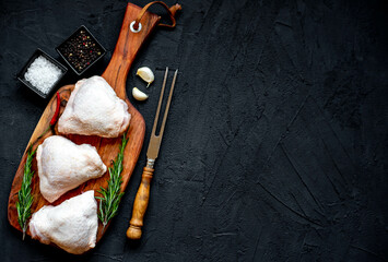 raw chicken thighs on stone background copy space for your text