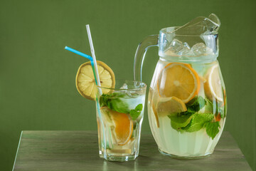 summer refreshing drink with lemon and ice in a decanter