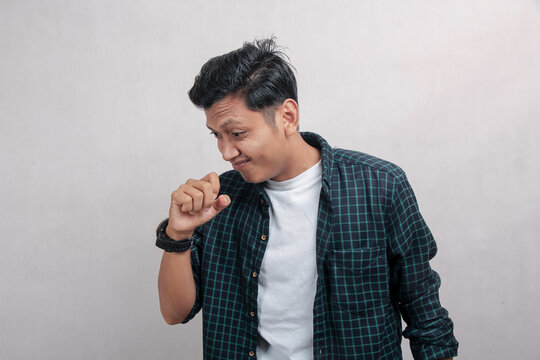 Curious millennial Asian man in plaid suit raising hand kissing hand isolated on white background. health photo concept