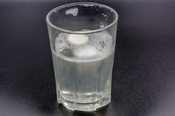 Dissolving instant effervescent tablets in a glass of water closeup