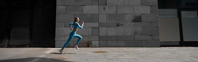 Beautiful fit young woman jogger is running outdoors