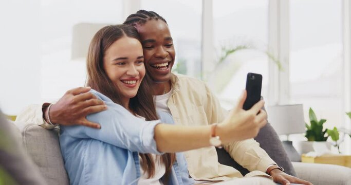 Tongue out, selfie and couple kiss in home on sofa and take profile picture for happy memory. Funny, interracial and black man and woman taking photo, kissing cheek and bonding for social media.