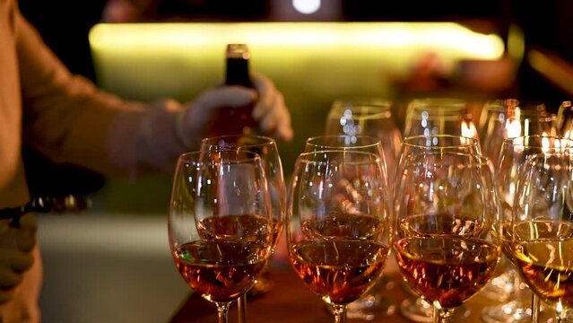 many glasses with wine or champagne in a dark room restaurant,fourchette table. barman open with corkscrew the bottle.evenimente poor light conditions 4k video
