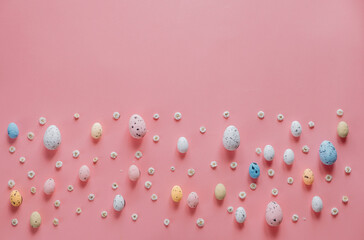 Easter composition. Easter eggs, flowers on pastel pink background. Flat lay, top view, copy space.