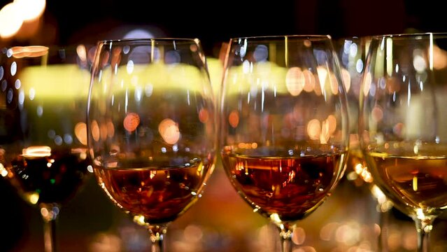 many glasses with wine or champagne in a dark room restaurant,fourchette table. barman open with corkscrew the bottle.evenimente poor light conditions 4k video