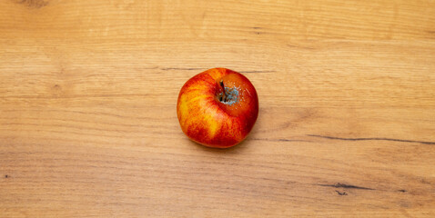 red rotten apple on a wooden table