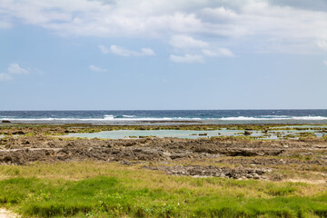 Fototapeta na wymiar 沖縄県八重瀬町具志頭のぐしちゃん浜の海と青空と岩の風景