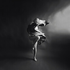 Elegant Contemporary Dance. Contemp Dancer in weightless skirt over the paper backdrop in studio. Woman dancing in Evening Silk Gown flying on Wind. Black and white image