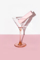 Pink sponge in a martini glass on pink and white background 