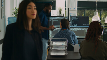 Software programmers talking about algorithms on big screen and tablet, analyzing html script...