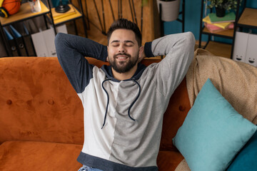 Tired man lying down on comfortable couch, taking a rest, daytime nap. Portrait of carefree...