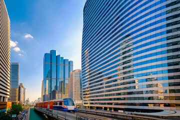 Naklejka premium Train in motion blur in business downtown of modern city of