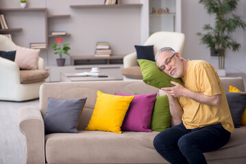 Obraz premium Old man with many pillows at home