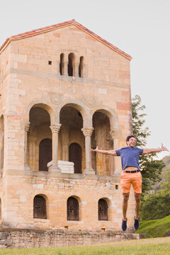 Inspirational fun jump movement. South asian mid adult man triumphing on travel vacations in Asturias