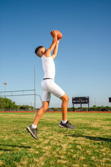 Youth male 7 on 7 football player catching the football