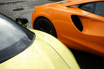 Lufteinlass eines modernen englischen Supersportwagen mit Mittelmotor in Orange bei Regen auf dem...