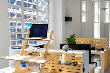 Modern and creative office with windows and technology on wooden parts