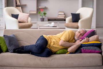 Old man with many pillows at home