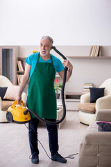 Old male contractor cleaning the house