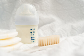 Fototapeta na wymiar Bottle with milk formula and diapers with a brush, the concept of a pleasant meal after bathing