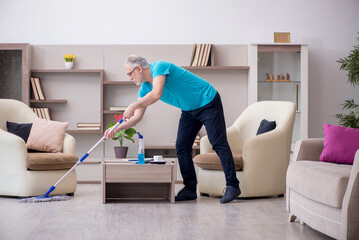 Old male contractor cleaning the house