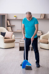 Old male contractor cleaning the house