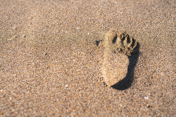 trace from a child's foot in the sand on a sunny day
