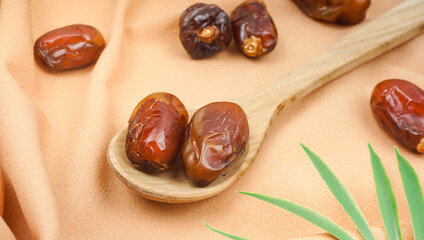 Wooden spoon with dried dates over bright background