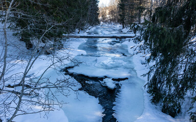 Beautiful frozen river in winter snowy forest