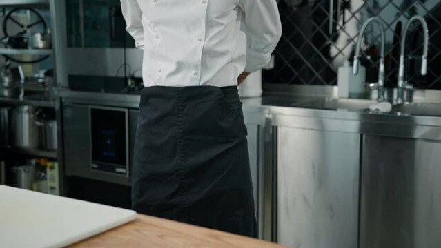 professional kitchen chef putting on uniform tying apron before starting work restaurant and kitchen concept
