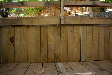 Wooden wall and floor in the garden. The wooden fence is made of boards.