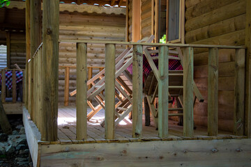Wooden fence, table, and chairs of a wooden house in the village. Terrace of a country house.