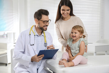 Obraz premium Mother and her cute baby having appointment with pediatrician in clinic. Doctor examining little girl