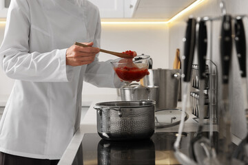 Professional chef cooking delicious dish in saucepan indoors, closeup