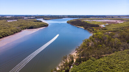 Beautiful famous Tinchi Tamba Wetlands, Bald Hills seen from above, spectacular wide river and speedboat. Shot from a drone, Brisbane, Queensland, Australia. 